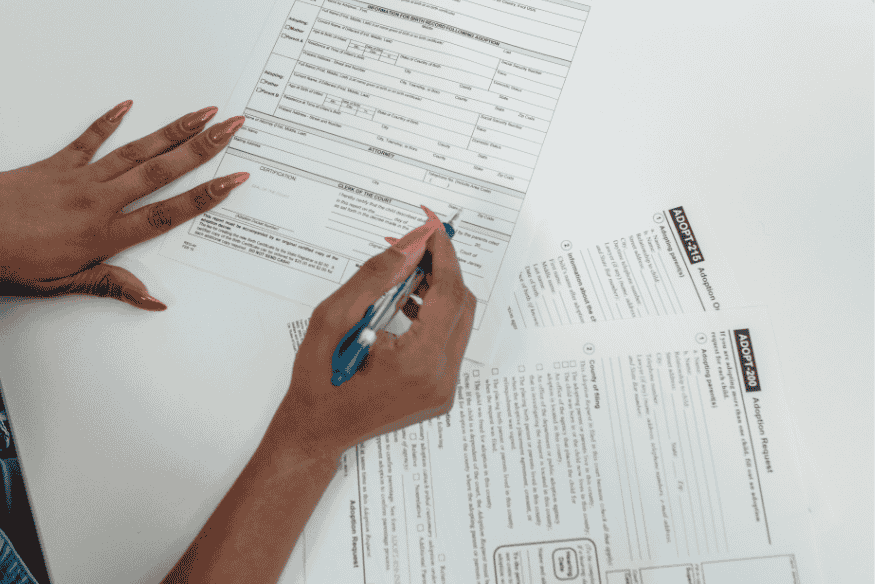 Personne remplissant un formulaire administratif, illustrant les démarches nécessaires pour constituer un dossier de prêt à taux zéro en 2025.