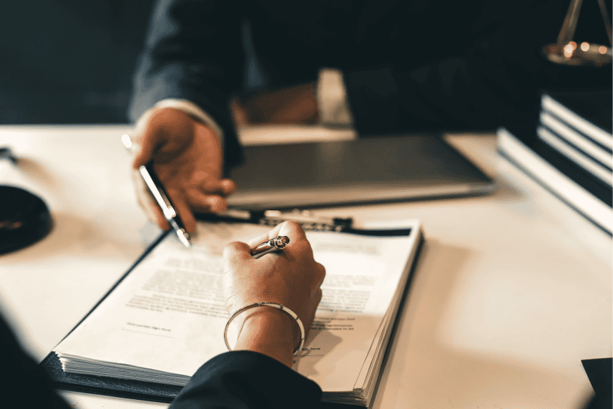 Signature de documents bancaires dans un bureau, représentant une offre de prêt pouvant être annulée selon des clauses suspensives.