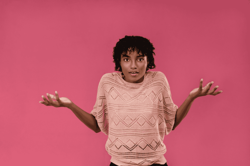 Femme avec les bras levés en signe d’hésitation comme symbole de doute entre Wero et virement instantané pour un usage quotidien